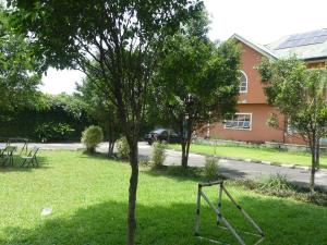 a tree in the grass in front of a house at Templar's Court in Port Harcourt