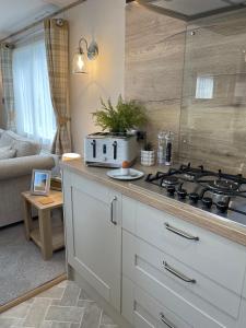 a kitchen with a stove top in a living room at Stones Throw Lodge in Padstow