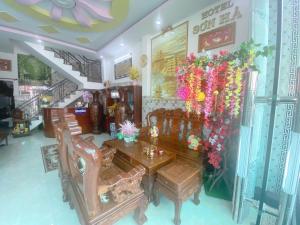 a dining room with a table and chairs and flowers at Khách sạn Sơn Hà in Can Tho