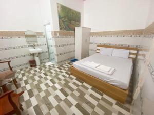 a bedroom with a bed and a table and a sink at Khách sạn Sơn Hà in Can Tho