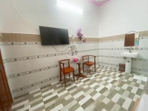 um quarto com uma mesa e duas cadeiras e uma televisão em Khách sạn Sơn Hà em Can Tho