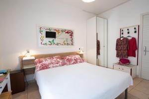 una camera da letto con un letto bianco e cuscini rosa di Le Petit Hotel a Lido di Jesolo