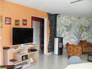 a living room with a flat screen tv on a wall at Brittany, House with swimming pool and spa in the countryside in Kersaint-Plabennec