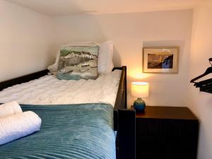 a small bedroom with a bed and a lamp at Great location very spacious. Sea and castle view in Marazion