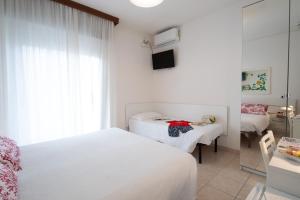 una camera d'albergo con due letti e uno specchio di Le Petit Hotel a Lido di Jesolo
