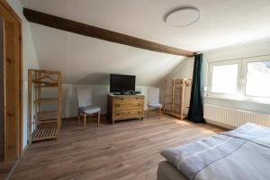 Schlafzimmer mit einem Bett und einem Schreibtisch mit einem TV in der Unterkunft Ferienhaus Zum Waldrand in Erfweiler