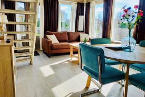 uma sala de estar com uma mesa e um sofá em Kustverhuur, Park Schoneveld, Duinroos 102 em Breskens