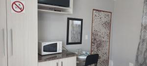 a microwave sitting on a counter in a kitchen at BBN Guest House in Phuthaditjhaba