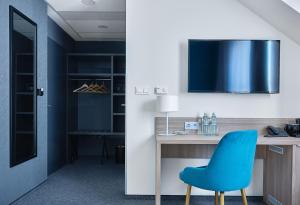 een blauwe stoel aan een bureau in een kamer bij Tennis & Country Club Hotel in Giebułtów