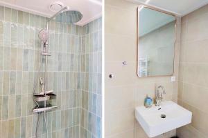 uma casa de banho com um lavatório e um chuveiro com um espelho. em Kustverhuur, Park Schoneveld, Duinroos 102 em Breskens