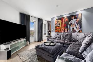ein Wohnzimmer mit einem Sofa und einem Flachbild-TV in der Unterkunft Luxurious large home Perfect for your group in Hafnarfjördur