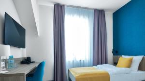 sypialnia z łóżkiem, biurkiem i oknem w obiekcie Tennis & Country Club Hotel w mieście Giebułtów