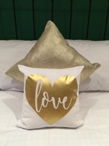 a gold heart pillow with the word love on it at Number Six in Truro