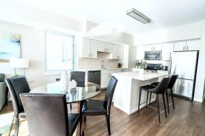 a kitchen and dining room with a glass table and chairs at Luxury Apt with High-End Amenities in Stamford