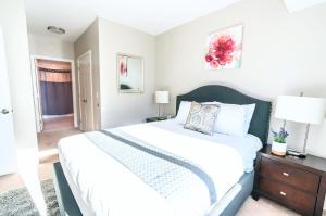 a bedroom with a large bed and a table with lamps at Luxury Apt with High-End Amenities in Stamford