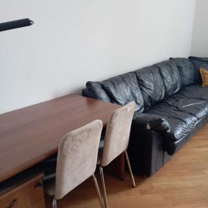 um sofá de couro preto ao lado de uma mesa de madeira em Raibetta Apartment em Gênova