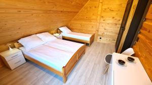 1 dormitorio con 2 camas en una cabaña de madera en Drewniana chata, 