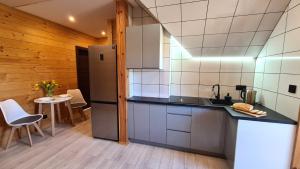 una cucina con frigorifero e tavolo di Drewniana chata 