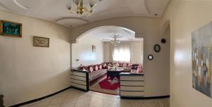 ein Wohnzimmer mit einem Sofa und einem Tisch in der Unterkunft Appartement meublé à louer in Meknès