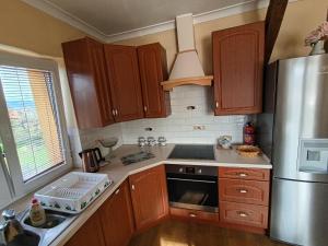 a kitchen with wooden cabinets and a stainless steel refrigerator at Apartament Tujka Żywiec in Żywiec