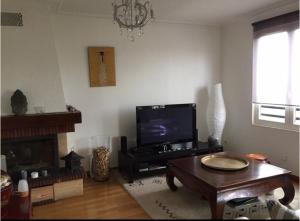 ein Wohnzimmer mit einem TV und einem Couchtisch in der Unterkunft Le Rosiers in Poissy