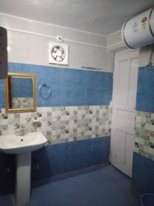 a blue and white bathroom with a sink and a mirror at Hotel Kanchan Dehradun in Dehradun