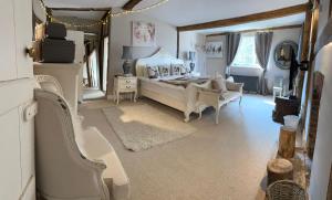 een grote slaapkamer met een bed en een stoel bij Church Farmhouse, Surrey, Sleeps 10, Large Garden in Crowhurst