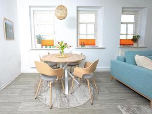 salon ze stołem, krzesłami i kanapą w obiekcie Voll ausgestattetes, neues Rennsteig Apartment Ruhla w mieście Ruhla