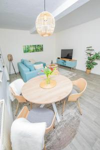 salon ze stołem i niebieską kanapą w obiekcie Voll ausgestattetes, neues Rennsteig Apartment Ruhla w mieście Ruhla