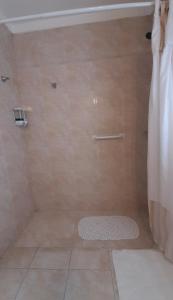 uma casa de banho com um chuveiro com uma cortina branca e um tapete em Apart Decorama em Dolores