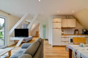 a living room with a couch and a kitchen at Haus Eiche in Hödingen +16 photos