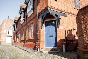 uma porta azul do lado de um edifício de tijolos em Historical 2 bed cottage - Chester centre - For 4 em Chester