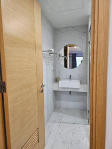 ein Bad mit einem Waschbecken und einem Spiegel in der Unterkunft Charlotte Boutique in Quy Nhon