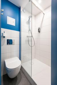 a bathroom with a toilet and a shower at ibis budget Mâcon Nord in Mâcon