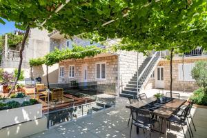 eine Terrasse mit einem Tisch, Stühlen und Treppen in der Unterkunft Hillside Apartments in Dubrovnik