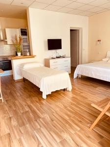 Duas camas num quarto com pisos em madeira em Casa Maka' em Olbia