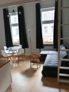 a living room with a couch and a table at Łokietkowo Apartamenty Szczecin Centrum in Szczecin