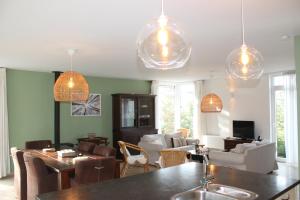 a living room with pendant lights and a dining room at Villa Elsa in Durbuy