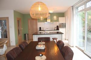 a living room with a wooden table and a kitchen at Villa Elsa in Durbuy +19 photos