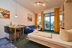 Camera con letto, scrivania e divano. di FeWo "Strandburg-Küken" 9005 - Fehmarn a Fehmarn