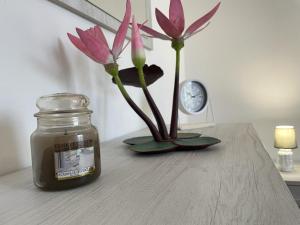 a jar of honey and a vase with flowers on a table at Water Lily Apartment in Bardello
