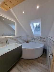 a bathroom with a large white tub and a sink at Hotel Alte Linde in Feldafing