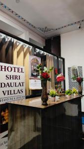 a store window with vases of plants on a counter at Shri Daulat Villas in Udaipur