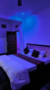two beds in a room with purple lights at Shri Daulat Villas in Udaipur