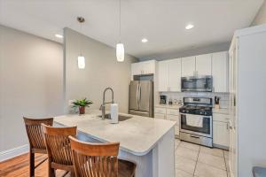 a kitchen with white cabinets and a kitchen island with chairs at Side by Side Townhomes in Tower Grove 916&918 in Tower Grove