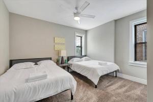 a bedroom with two beds and a ceiling fan at Side by Side Townhomes in Tower Grove 916&918 in Tower Grove