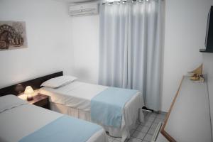 a hotel room with two beds and a window at Hotel Pousada Estacao Do Sol Natal in Natal