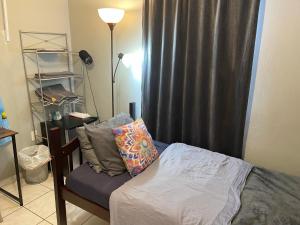 um quarto com uma cama com uma cortina preta em Best Value inside City Miami, Near Airport, Beach, Center & Metro em Miami