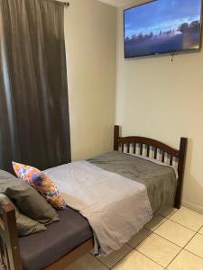 1 dormitorio con 1 cama y TV de pantalla plana en la pared en Best Value inside City Miami, Near Airport, Beach, Center & Metro en Miami