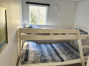 two bunk beds in a room with a window at Nice cottage located by the lake Nommen in Björköby